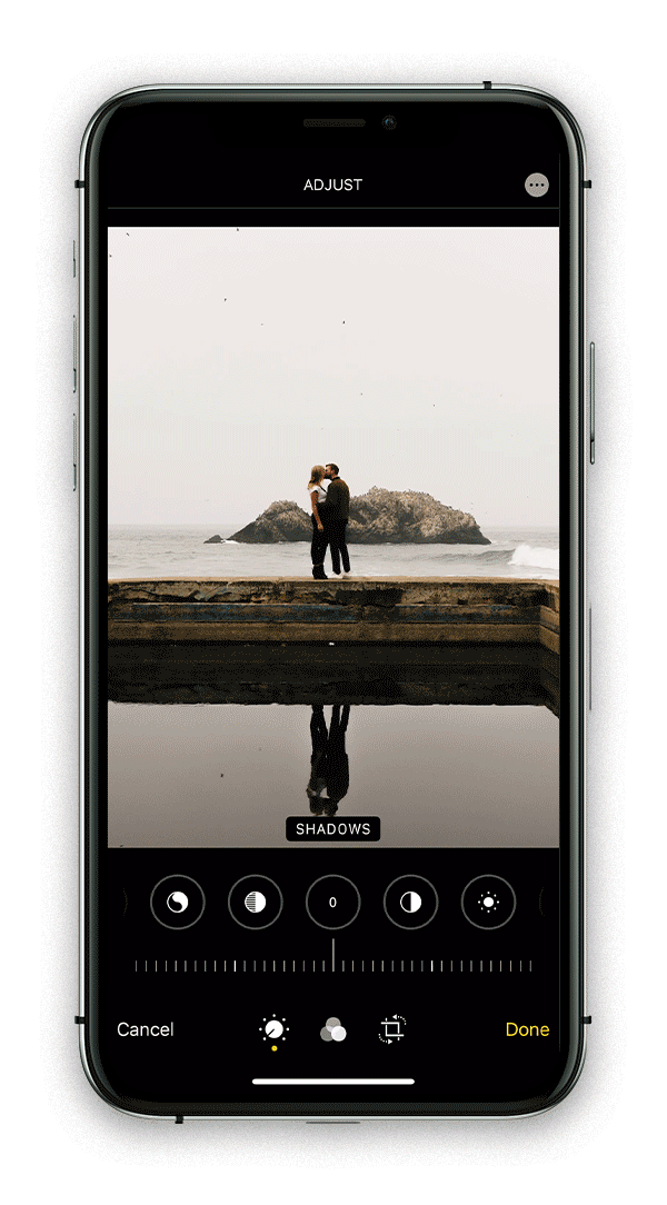 Adjusting shadows in iphone native photo editor to edit a photo of a couple kissing on the coast