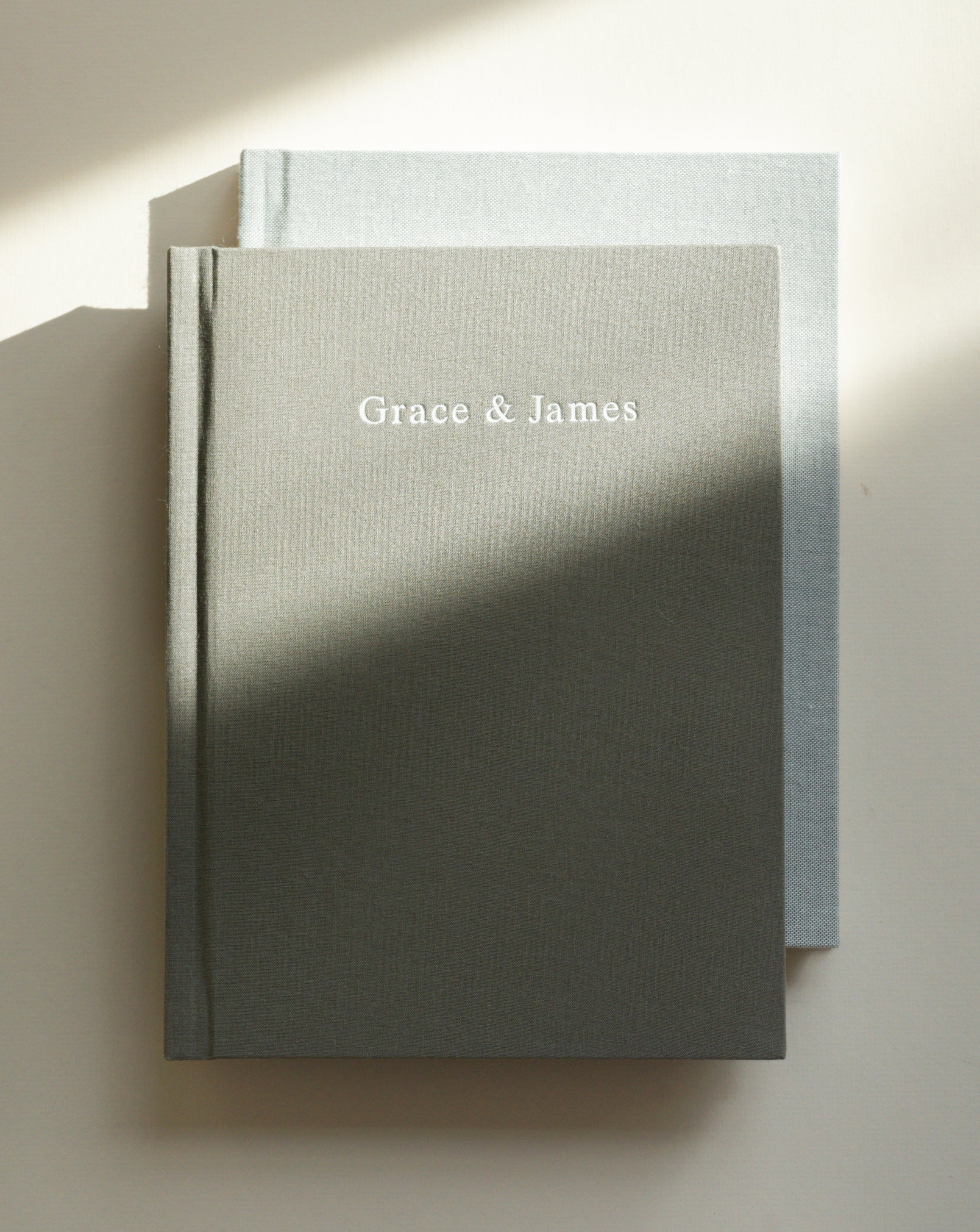 Layflat Photo Albums stacked showcasing foil stamped cover title